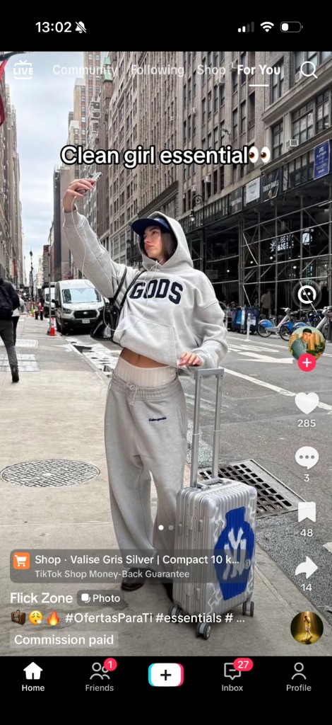 TikTok Shop screenshot: street UGC with a silver suitcase and a Shop product bar
